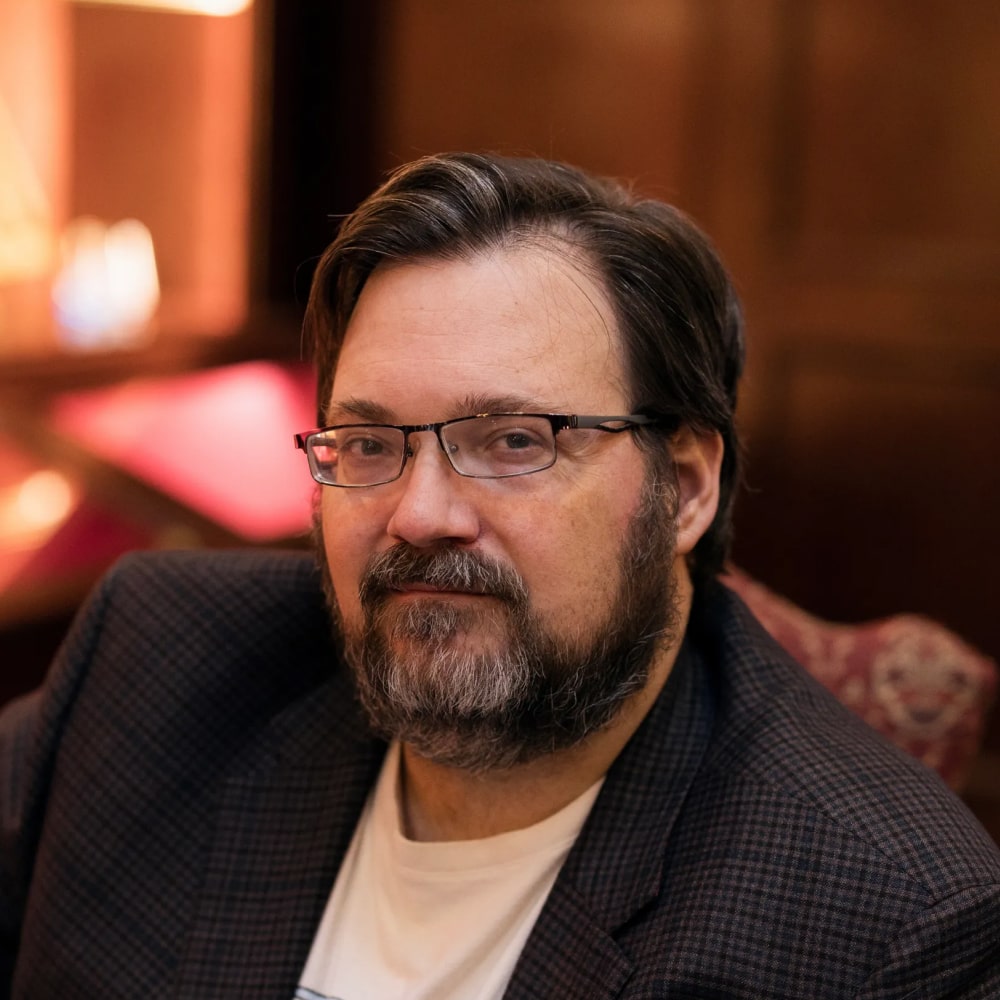 Portrait de Brandon Sanderson, auteur célèbre de fantasy épique, notamment de la saga Fils-des-Brumes et de l'univers Cosmere.