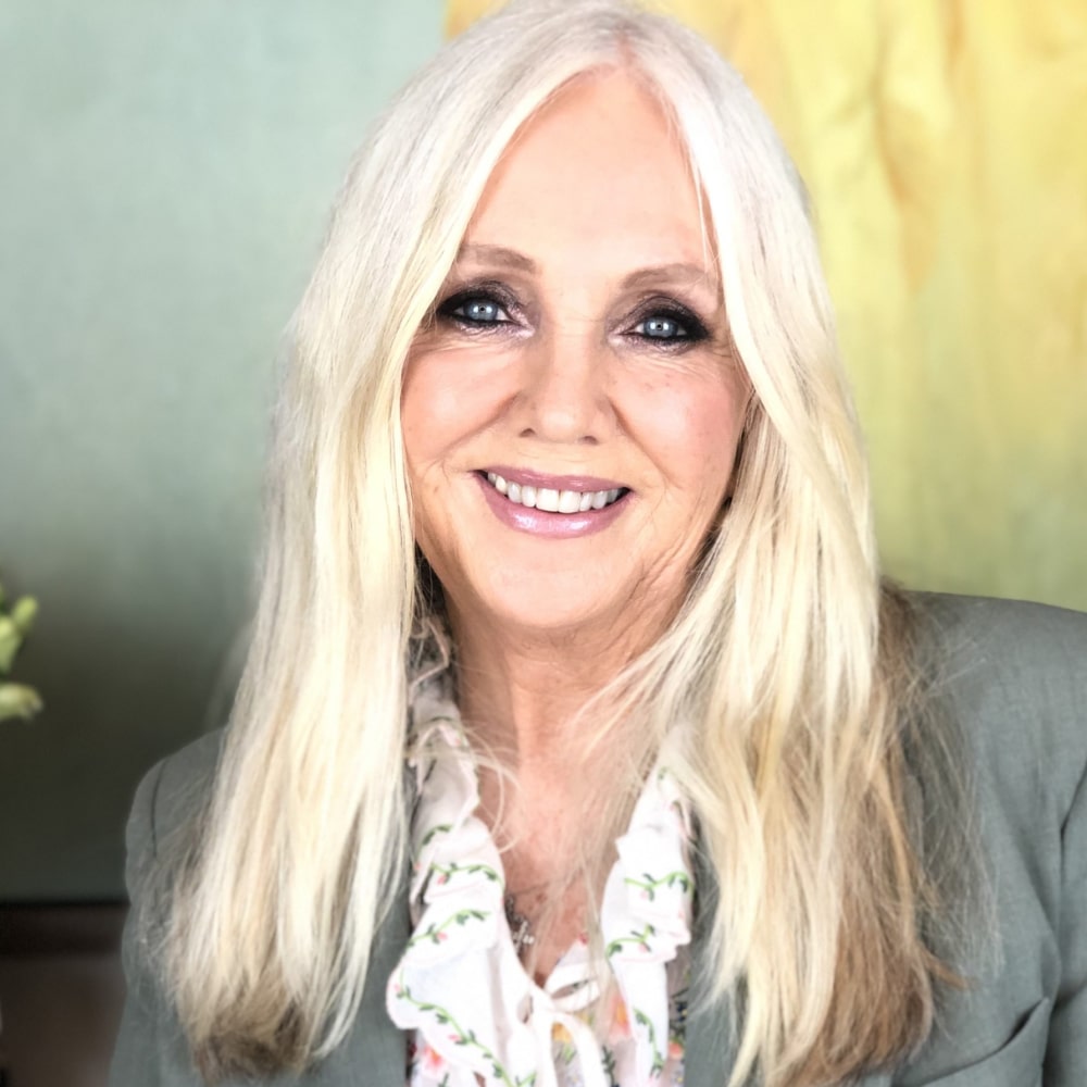 Portrait de Rhonda Byrne, autrice de la série "Le Secret", célèbre pour ses ouvrages sur la loi de l'attraction et le développement personnel.