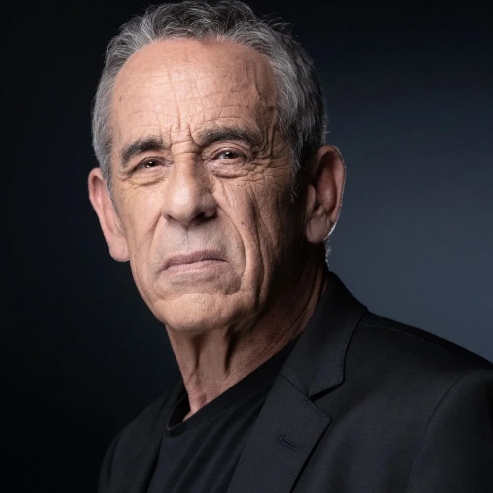 Photo de Thierry Ardisson, animateur et auteur français, vêtu de noir et souriant face à une sélection de ses livres.