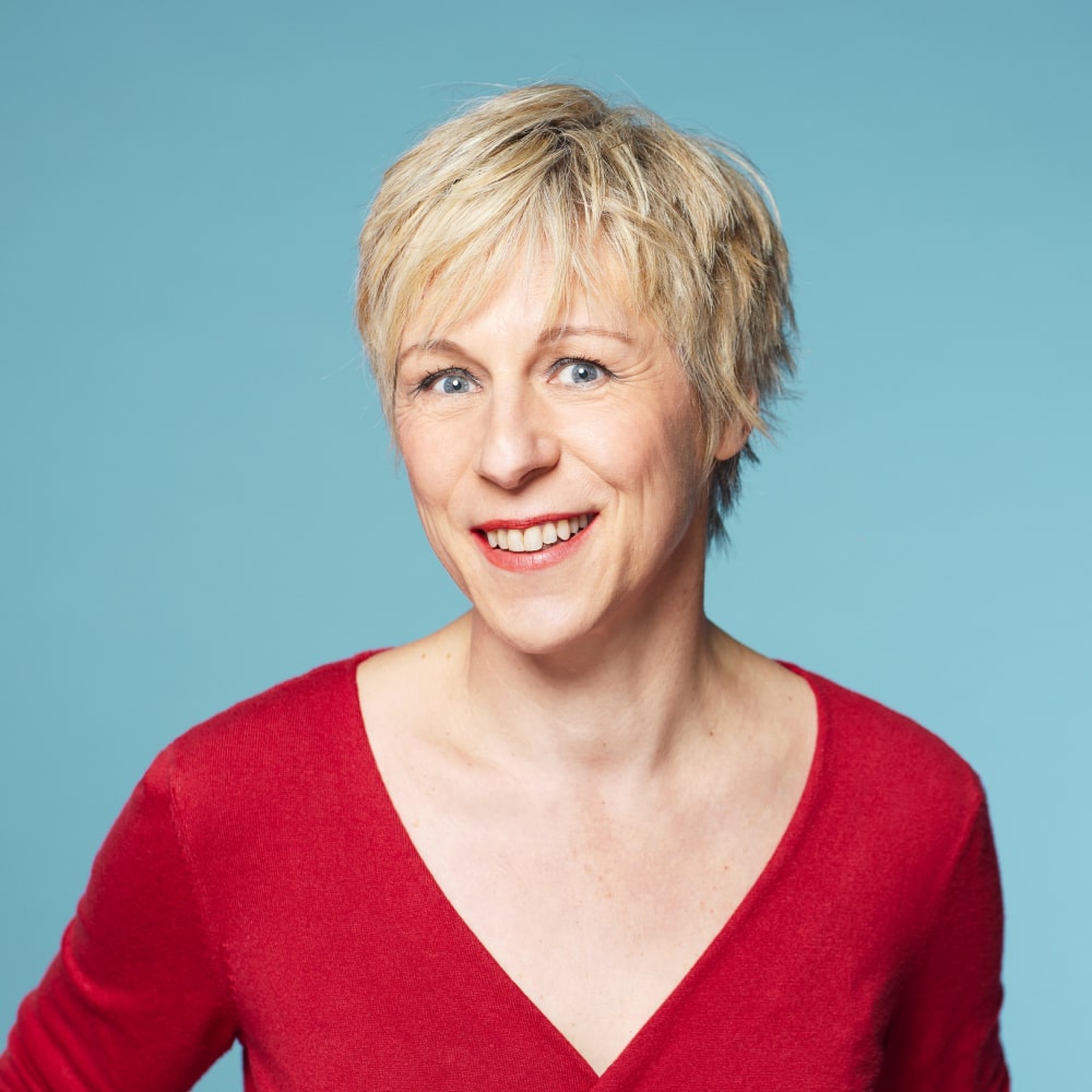 Portrait d’Agnès Ledig, romancière française, souriante dans un cadre champêtre et apaisant.