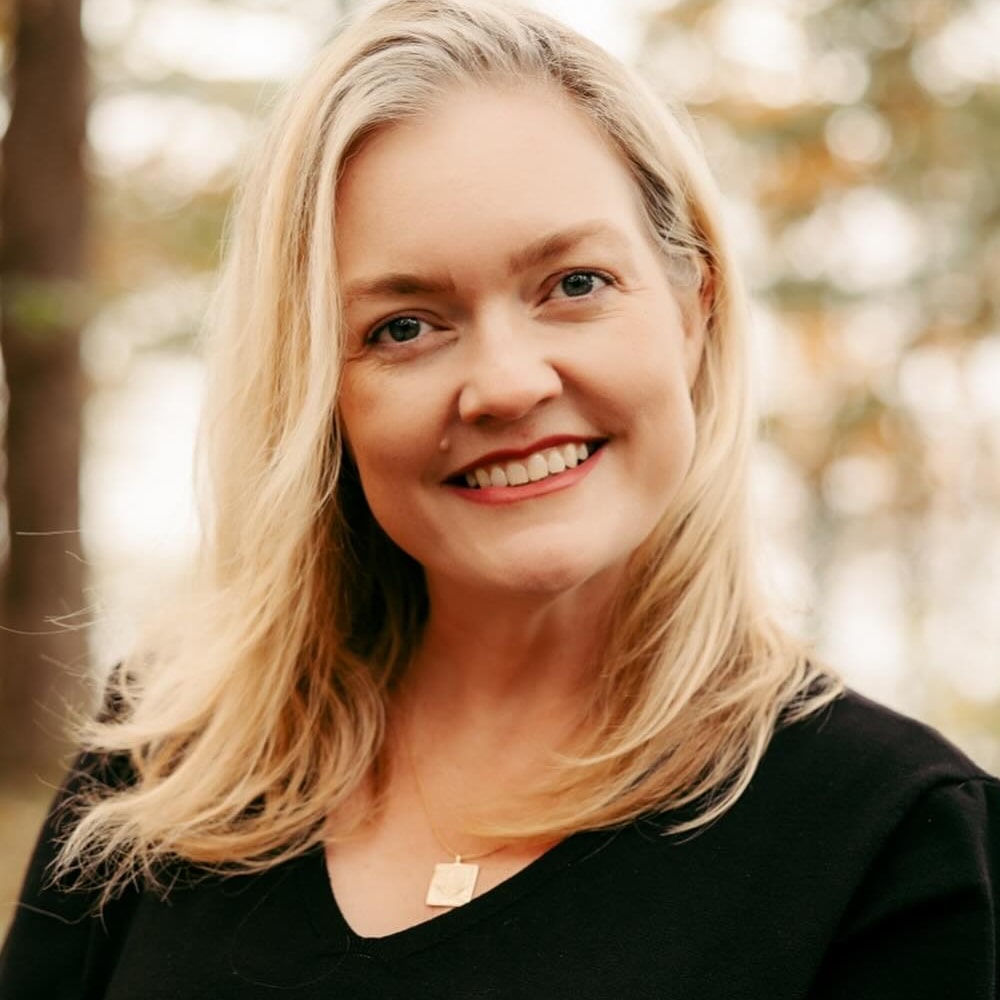 Portrait de Colleen Hoover, autrice américaine de romances à succès, souriante devant une étagère remplie de ses romans best-sellers.